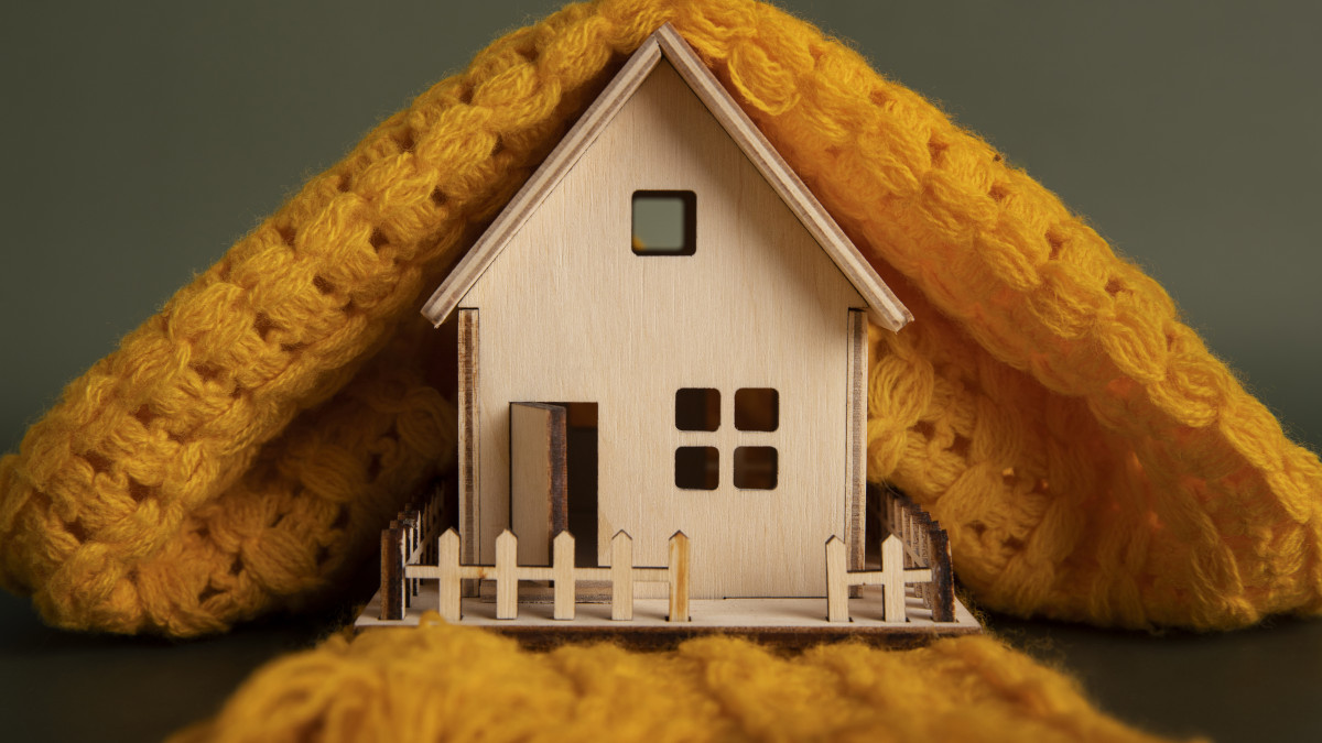 une petite maison en bois recouverte d'un manteau de laine orange